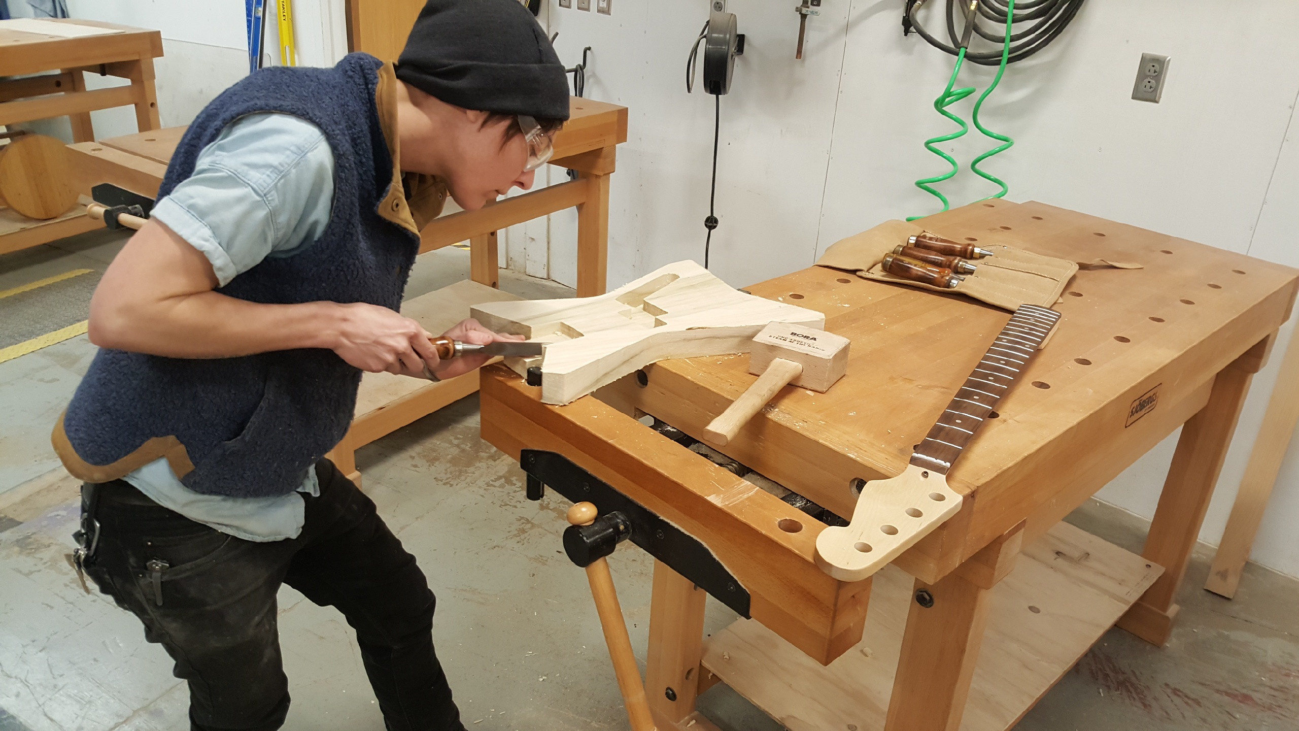 Sara Sanders chisels out the neck pocket of her custom guitar body