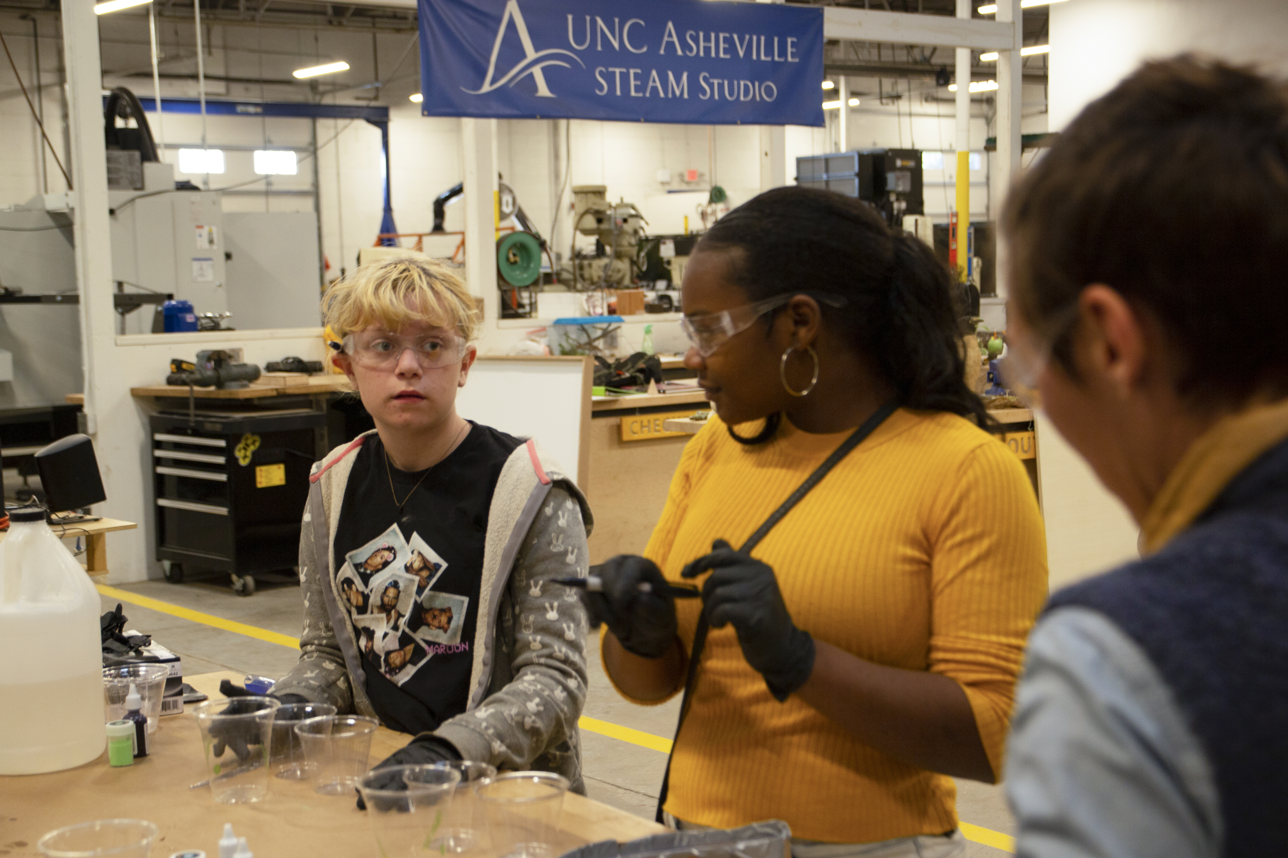Sara Sanders instructs students how to pour resin