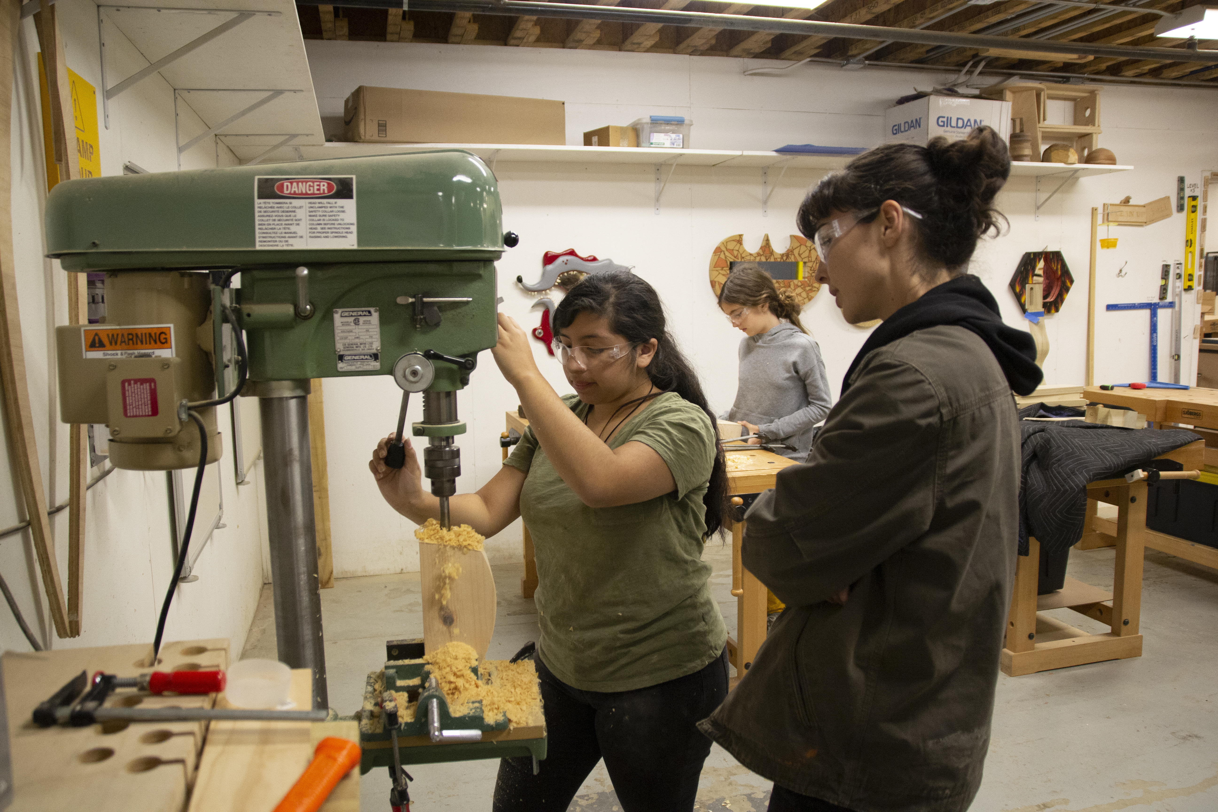 SkillSet Woodshop Instructor teaches student how to use the drillpress