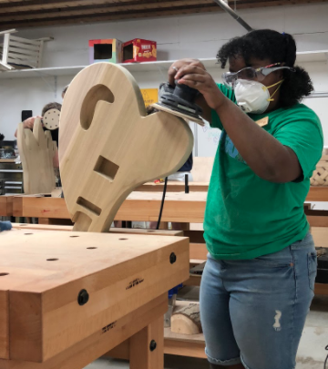 A student sands their guitar body